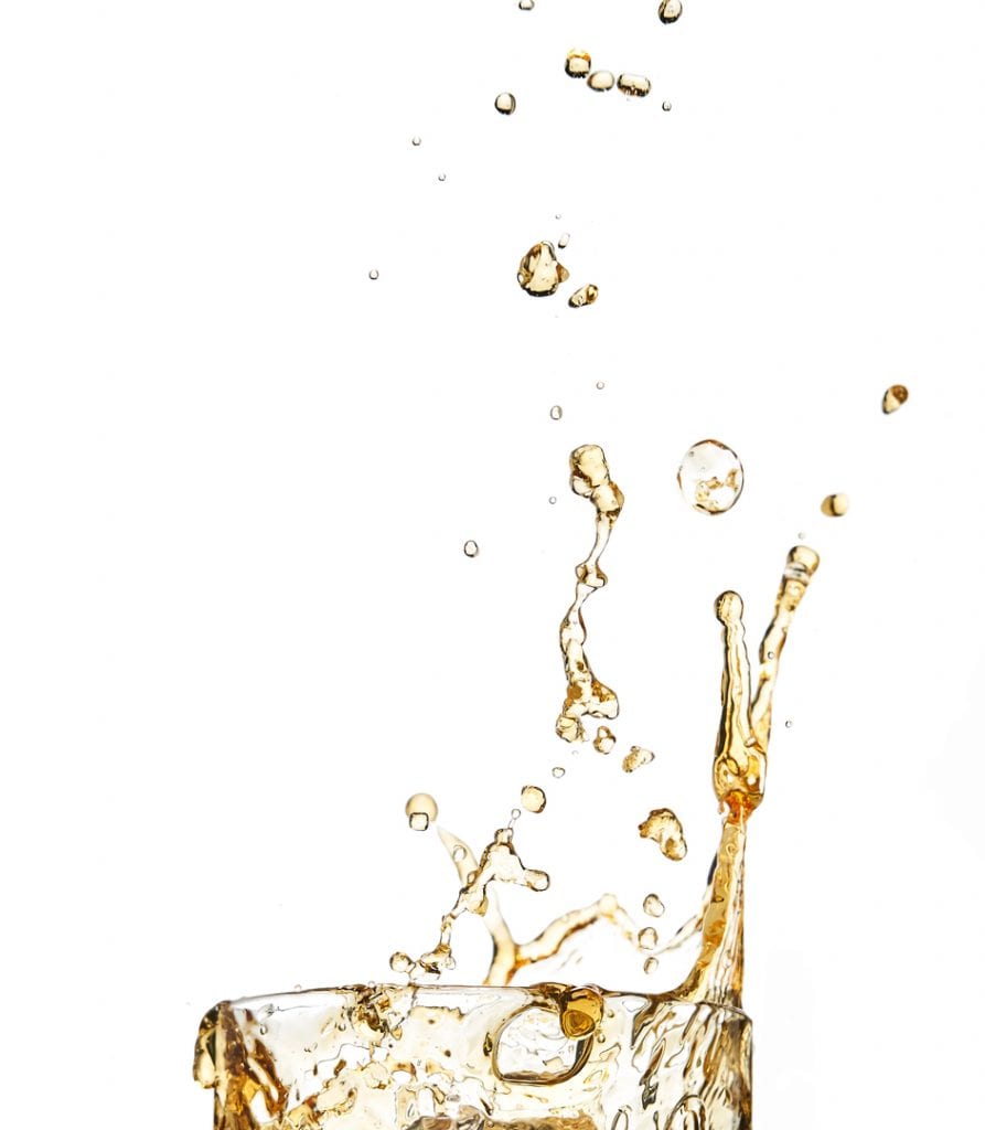 merge Liquid splashing up from glass against white